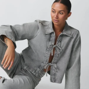 Grå jeansjacka med knyt / gina tricot - Snygg grå jeansjacka med unika knytningar framtill. Jackan har en avslappnad passform och långa ärmar. Perfekt för en cool och avslappnad stil.