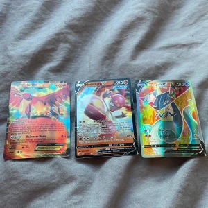 Pokémonkort: Ho-Oh V, Medicham V, Dragapult V - Tre Pokémonkort med holografisk design: Ho-Oh V med 160 HP, Medicham V med 210 HP och Dragapult V med 210 HP. Korten har färgglada och detaljerade illustrationer som framhäver varje Pokémon. Perfekt för samlare eller spelare som vill förstärka sin kortlek. Obs igen frakt!