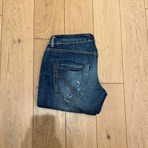 Mörkblå Dondup jeans - Snygga populära dondup jeans i modellen Noah, stl 30. Riktigt feta detaljer och slitningar. Skick 9/10. Skriv vid minsta fråga eller fundering! Pris inte hugget i sten!