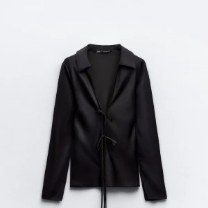 Svart långärmad topp från Zara - Elegant svart långärmad topp från Zara med knytning framtill.