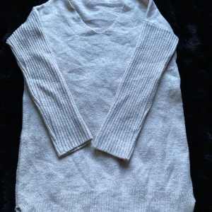 Vit stickad tröja från Dilvin - Mysig vit stickad tröja från Dilvin med v-ringning och ribbade långa ärmar. Perfekt för kyliga dagar när du vill hålla dig varm och stilren. Tröjan har en enkel och klassisk design som passar till det mesta. 🧶✨