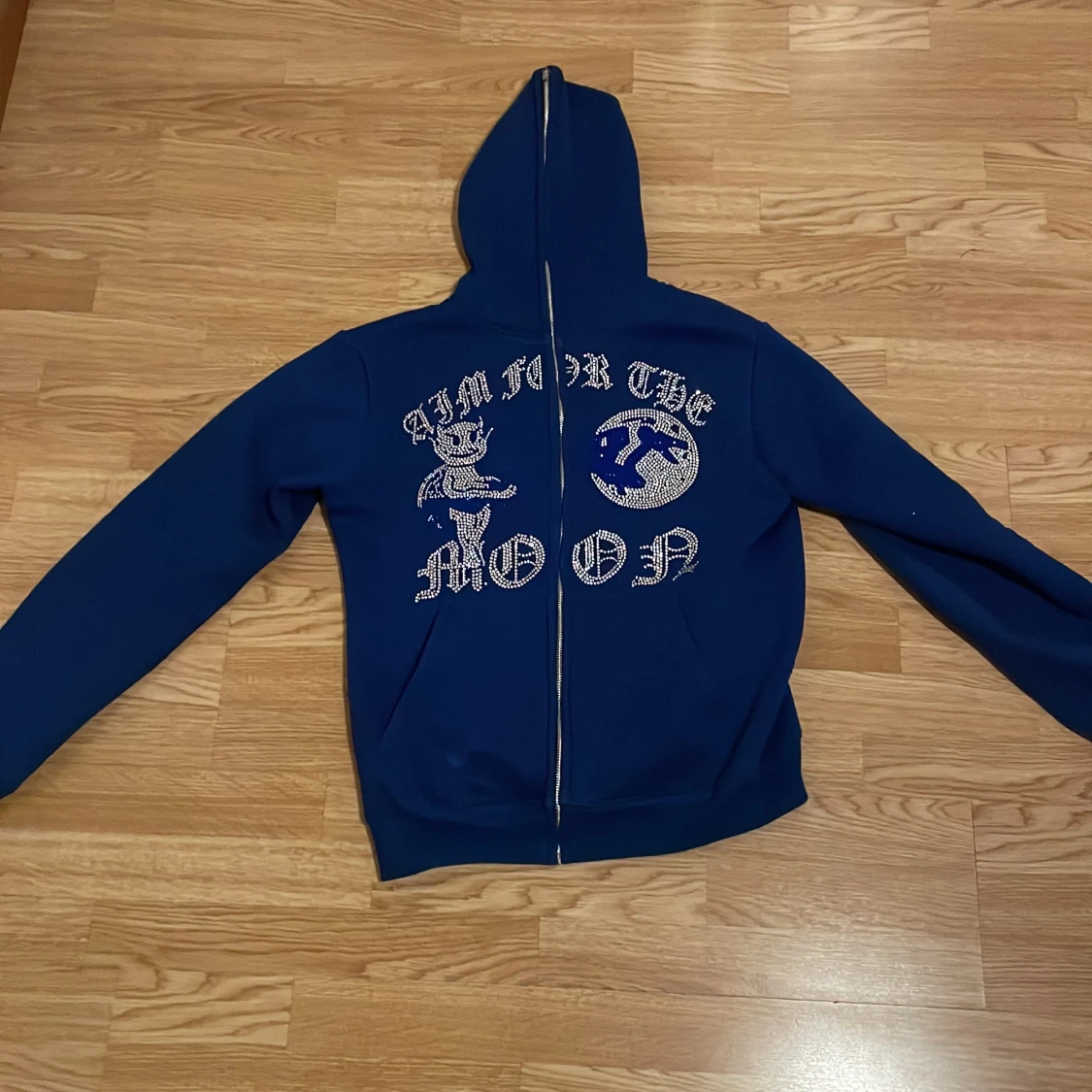 Blå hoodie med dragkedja och text