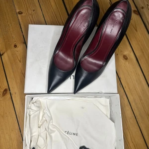 Svarta pumps från Céline - Eleganta svarta pumps från Céline med spetsig tå och hög klack. Skorna har en stilren design och är tillverkade i skinn. Perfekta för en sofistikerad look.