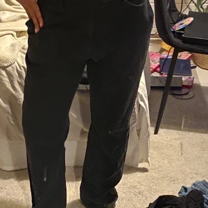 Svarta/gråa kostymbyxor - Snygga svarta/gråa kostymbyxor med en utsvängd/bootcut passform. Perfekta för en stilren look. Byxorna har knapp och dragkedja framtill. Byxorna är i superfint skick.