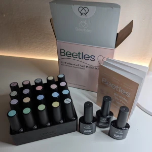 Beetles Gel Nagellack Pastell - 23 delar för eleganta & trendiga naglar! HELT NY - Ge dina naglar en drömlik makeover med Beetles Gel Nagellack Pastellset! Detta underbara set innehåller 20 trendiga färger, från eleganta matta toner till gnistrande glitter, samt 3 över- och underlack för den perfekta finishen. Oavsett om det är vår, sommar eller fest – här finns nyanser för alla tillfällen!  Varför du kommer älska det: Lång hållbarhet – Upp till 21+ dagar med hög glans och färgbeständighet. Lätt att applicera – Härdas under UV/LED-lampa på 60–90 sekunder.     HELT NY, OÖPPNAD!