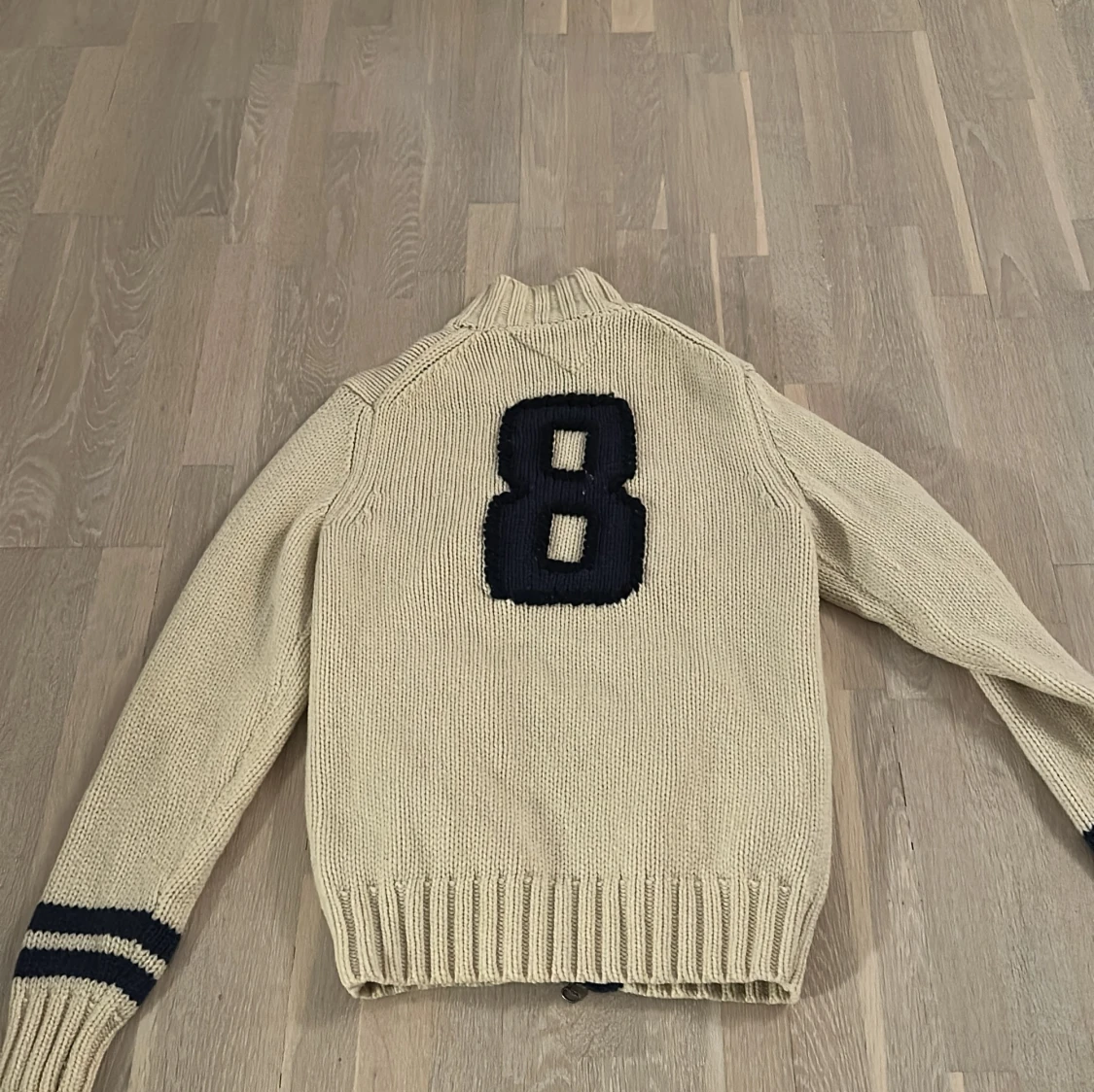 Beige stickad tröja med nummerdetalj