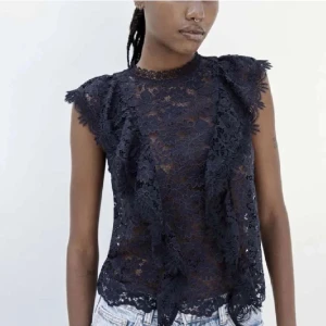 Mörkblå spetsblus Zara  - Elegant mörkblå spetsblus med vackra blommiga detaljer. Blusen är ärmlös och har en fin struktur som ger en lyxig känsla. Perfekt för att lyfta vilken outfit som helst.