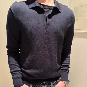 Säljer en stilren svart långärmad pikétröja från Uniqlo. Tröjan har en klassisk krage och knappar framtill, perfekt för en avslappnad men ändå uppklädd look. Passar till allt. Den är i merinoull Skriv om ni har frågor 