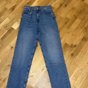 Blå jeans från ASOS Design - Snygga blå jeans från ASOS Design med klassisk femficksdesign. De har en rak passform och är tillverkade i ett slitstarkt denimtyg. Storlek 36