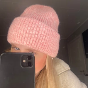 Mössa - Säljer en söt rosa stickad mössa med ribbad design. Perfekt för att hålla värmen under kyliga dagar. Mössan har en klassisk uppvikt kant och en mjuk känsla. Helt ny med lapp kvar, på bilderna har jag min egna mössa utan lapp men den jag säljer har lappen kvar. Säljer då jag råkade beställa två exakt likadana