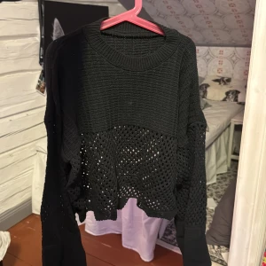 Svart virkad tröja med hålmönster - Säljer en svart virkad tröja med ett coolt hålmönster. Tröjan har långa ärmar och en croppad design som ger en trendig look. Perfekt för lager-på-lager-stil eller som statement-plagg. Fick tröjan i present och det finns ingen lapp. Aldrig använd💕