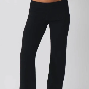 Svarta ribbade byxor - Snygga svarta byxor med ribbad midja och bootcut-stil. Perfekta för en avslappnad look med en skön passform. De är både stilrena och bekväma, vilket gör dem till ett mångsidigt tillskott i garderoben.