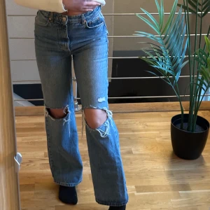 Blå jeans med slitna knän - Snygga blå jeans från Gina Tricot i en klassisk denimstil. De har en hög midja och raka ben med slitna detaljer vid knäna för en trendig look. 