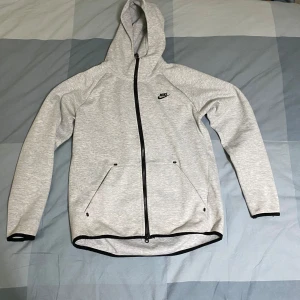 Nike tech grå - Hoodien är i bra skick och är köpt från Plick. Den passar perfekt för en skön höst dag.   Kontakta mig vid frågor eller om du vill ha fler bilder. Du kan också kontakta mig om du har ett förslag på ett byte!