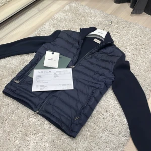 Moncler Cardigan - Säljer nu denna extremt snygga Moncler Cardigan perfekt nu till hösten!  Absolut inga täcken på användning, skick 10/10! Köpt på Care Of Carl för 9999kr, allt org dvs Kvitto och Tags ingår vid köp.