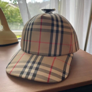 Burberry Keps - Nyskick  - Burberry Keps med justerbart spänne Nyskick Storlek: L  Inköpt på NK för ca 3 år sedan Har ej kvar kvittot (Svar ja, den är äkta. kan skicka mer bevis i PM)  