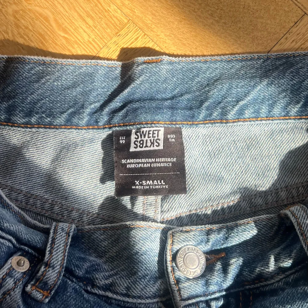 Säljer ett par klassiska blå jeans från Sweet Skts. De har en baggy passform och är tillverkade i slitstarkt denim. Perfekta för en avslappnad stil. Jeansen har fem fickor och knappar i midjan.. Jeans & Byxor.