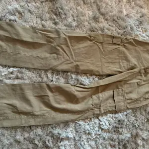 Säljer ett par snygga beige cargopants. De har flera praktiska fickor på sidorna och är perfekta för en avslappnad stil. Byxorna är i bra skick och passar perfekt för höst och vår.