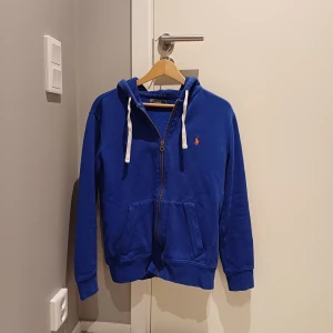 RALPH LAUREN ZIP HOODIE - Vi säljer nu denna ralph lauren zip hoodien i bra skick. Den är lite luten i storlek så passar även storlek S utan problem. Bara att skriva vid funderingar.