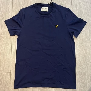Lyle & Scott - T-shirt - Navy Blue  - Säljer denna Lyle & Scott t-shirt, då den ALDRIG HAR ANVÄNTS. Ja, den är inte ny (dvs. Köptes för ett par år sedan), men den har aldrig kommit till användning utan bara legat i garderoben. Storleken L. Skick: 10/10. Vid frågor - hör av er gärna! 