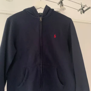 Ralph lauren zip hoodie  - Säljer denna mörkblå Ralph lauren hoddien i storlek L(14-16) för den är för liten den är använd Max 4 gånger  Så den är i ny sick !skriv vid frågor och intresse !Pris går att diskutera! 