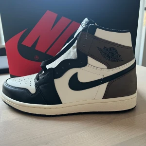 Jordan 1 High Dark Mocha - Helt nya Jordan 1 High Retro ’Dark Mocha’. Skick: 10/10 ”Deadstock”  Storlek: 42,5 (US 9)  Kommer med originalbox och alla tillbehör.  Köpta på SNKRS när de släpptes 2020. Kvitto finns. Finns på fler sidor.