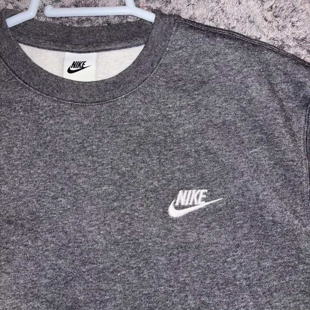 Säljer en grå sweatshirt från Nike med deras logga broderad på bröstet. Oanvänd, mycket skön, i storlek M för en billig peng!. Neuletakit & Villapaidat.