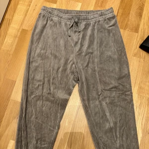 Gröna  pyjamasbyxor med snörning - Snygga gröna pyjamasbyxor med diskret randigt mönster och bekväm snörning i midjan. Perfekta för en avslappnad stil med elastiska benslut.