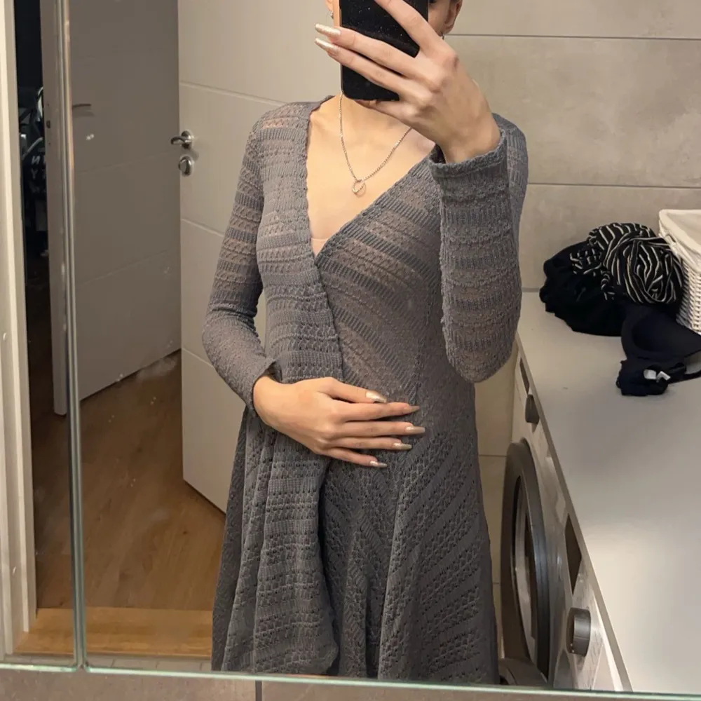 Säljer en snygg grå lång kofta. Den är stickad med ett öppet mönster och har långa ärmar. Perfekt för lager-på-lager-stil och passar till många olika outfits.. Neuletakit & Villapaidat.