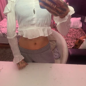 Vit blus från H&M - Säljer en söt vit blus från H&M med volangdetaljer. Blusen har långa ärmar och en luftig passform, perfekt för vår och sommar.🤍