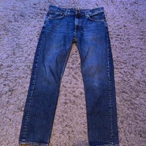 Nudie jeans  - Snygga blå jeansbyxor med klassisk femficksdesign och rak passform. Perfekta för en avslappnad stil. Storlek w34 L32 men passar w33 också.   Tveka inte om ni har några funderingar🥂