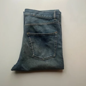 ARKET Coast Jeans - Blå jeansbyxor med knappgylf. ARKET levererar bra kvalitets jeans med ekologiskt bomull