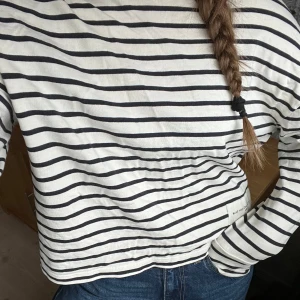 Randig långärmad tröja från MNG - Säljer en stilren randig tröja från MNG med svart och vit design. Tröjan har långa ärmar och en avslappnad passform, perfekt för en casual look. Märket 'Make Your Own Art' ger en unik touch. Perfekt för alla säsonger!