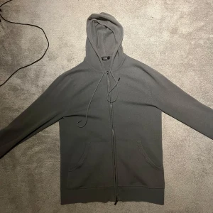 Grå kashmir hoodie från gobi cashmere - Grå slim fit kashmir hoodie i storlek S från gobi cashmere. Hoodien finns inte längre kvar på gobis hemsida men den köptes förra året för cirka 3000kr. Det är geniunt den skönaste tröjan jag någonsin haft. Jag är 188 och väger 70kg och den passar mig nästan perfekt, lite tajt och kort i ärmarna, vilket gör den väldigt stor för att vara S. Tröjan har användts en del och har lossnat lite vid dragkedjan, men inga övriga defekter förutom ett litet hål. Nypris (förut): 3000, mitt pris: 850.
