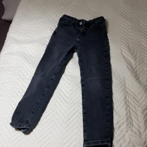 Svarta jeansbyxor - Snygga svarta jeansbyxor med en klassisk design. De har en knapp och dragkedja framtill samt fickor både fram och bak. Perfekta för en stilren look.