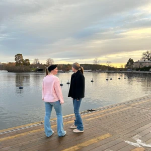 Stickad panband i svart  - Två stickade pannband i svart och beige. Båda har en ribbad design med en dekorativ rosett framtill. Perfekta för att hålla värmen och stilen under kyliga dagar.