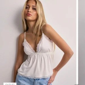 Vit spetsdetaljerad linnetopp - Säljer en söt vit linnetopp med smala axelband och v-ringad spetsdetalj. Toppen har en avslappnad passform och är perfekt för varma dagar. Den är både stilren och bekväm. 🩷 säljer då den inte sitter rätt på mig🩷