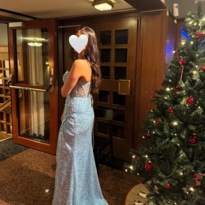 Glittrig ljusblå långklänning - Säljer en fantastisk glittrig ljusblå långklänning med smala axelband och en elegant slits. Perfekt till bröllop eller bal! Skriv gärna om du har frågor!🤍