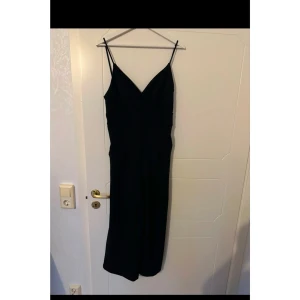 Byxdress/Jumpsuit - Svart jumpsuit som endast är använd fåtal gånger. Benen slutar strax över anklarna på mig.