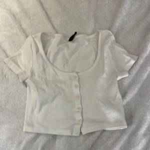 Vit kortärmad topp från Divided - Säljer en vit kortärmad topp från Divided. Använt fåtal gånger. Storlek XS.