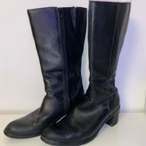 Svarta stövlar med dragkedja - Snygga svarta stövlar i skinn med dragkedja på sidan. De har en bekväm klack och en stilren design som passar perfekt till olika tillfällen. Perfekta för utekvällar året om. Strl 40💞