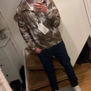 Camouflage vindjacka från Woolrich - Säljer en skön och lätt Windbreaker från woolrich. Köptes sprillans ny men växte ur den efter ett tag och nu är det dags för en ny jacka inför våren. Skulle rekommendera att du har storlek L som störst i tröjor för att få den bästa passformen. Inte använd så sjukt mycket då den blev köpt sent under hösten. Har bild på när den var ny. Priset kan gå ner vid lätt och snabb affär. Hör av dig vid funderingar!