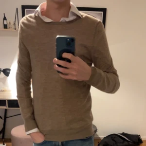 Beige kashmirtröja - Säljer en stilren beige kashmirtröja med långärmad design. Perfekt för en elegant och bekväm look. Tröjan är tillverkad i 100% kashmir vilket ger en lyxig känsla.