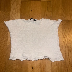 Vit tube topp från Bik Bok - Vit cropped tube top från vinbok perfekt för sommarn. Toppen är kortärmad med en elastisk och smockad design som ger en fin passform. !