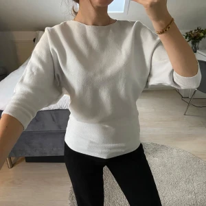 Vit tröja med trekvartsärm - Snygg vit tröja med trekvartsärm. Perfekt för en stilren look. Tillverkad i ett mjukt material som ger en bekväm känsla.