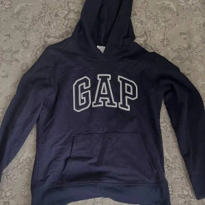  Mörkblå GAP hoodie  - En mörkblå Hoodie från GAP, storlek XS, har bara kommit till användning en gång, Unisex, nypris 379kr men säljer för 200kr. 