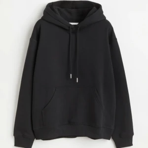 Svart hoodie - Säljer en klassisk svart hoodie som är perfekt för alla tillfällen. Den har en stor ficka framtill och justerbar dragsko i huvan. Materialet är mjukt och bekvämt, vilket gör den idealisk för både mysiga hemmakvällar och vardagsäventyr. Helt ny (har ej etikett) från hm 