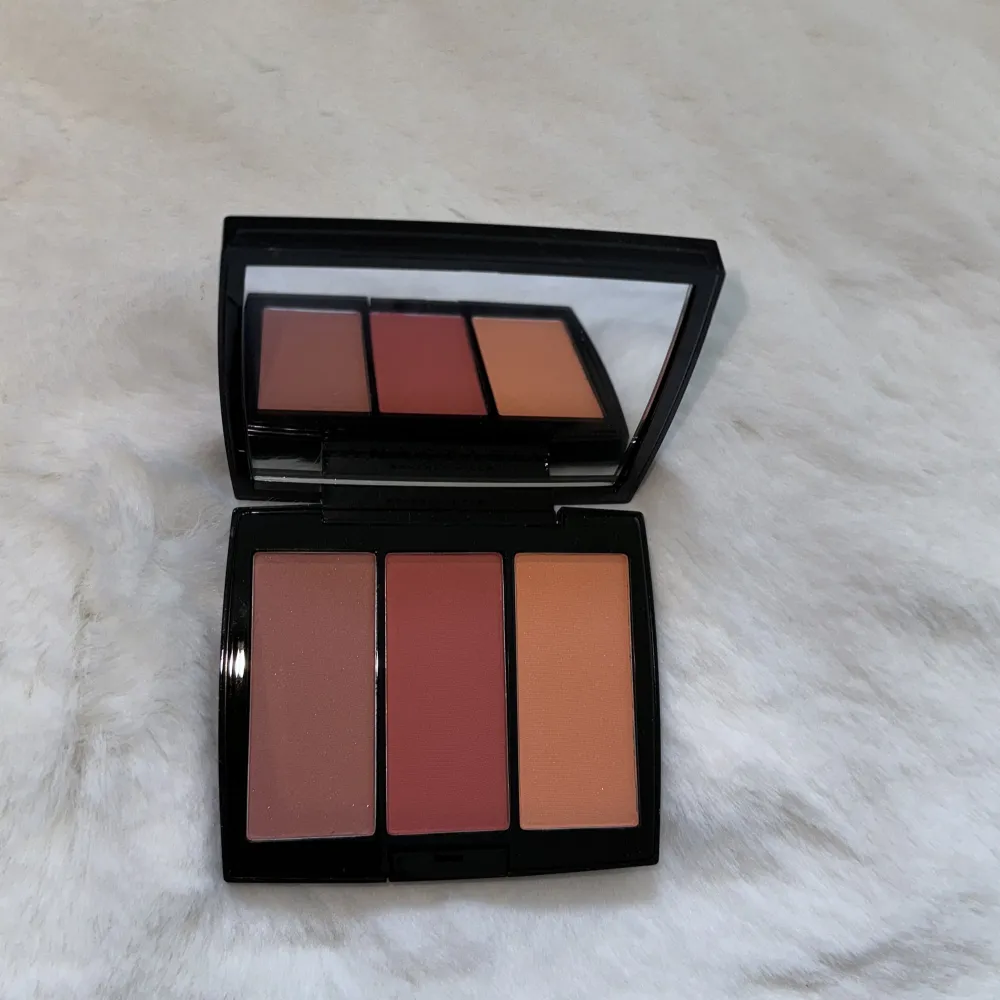 Säljer en superfin Blush Trio i nyansen Peachy Love från Anastasia Beverly Hills. Den innehåller tre olika rougefärger: en mjuk persikoton, en djupare rosa och en varm orange. Perfekt för att ge kinderna en fräsch och livfull look! Kompakt och lätt att ta med sig, med en praktisk spegel i locket.. Skönhet.