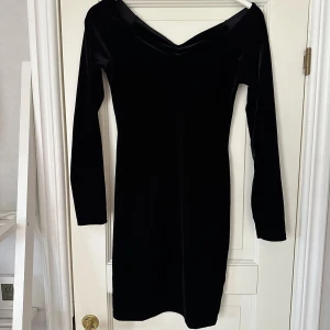 Sammetsklänning - Svart klänning i sammetsliknande material från Miss Selfridge i storlek 38 med långa ärmar. Kan dras ut lite på axlarna. Endast använd vid ett tillfälle så i gott skick.