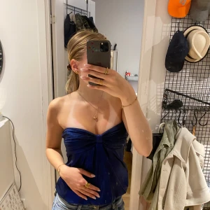 Blå topp - Hej, säljer denna snygga blåa topp då jag inte använder den längre. Färgen är blå men som lite glitter färgad, försökte få en bild på sista bilden🥰 (vita koftan och datorfodral är INTE till salu, bara exempel på hur man skulle kunna styela den❤️)